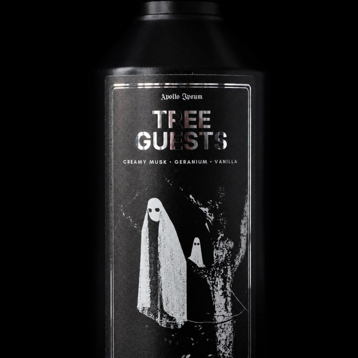 Close-up of the Tree Guests Fabric Perfume label on a warm amber home fragrance spray
