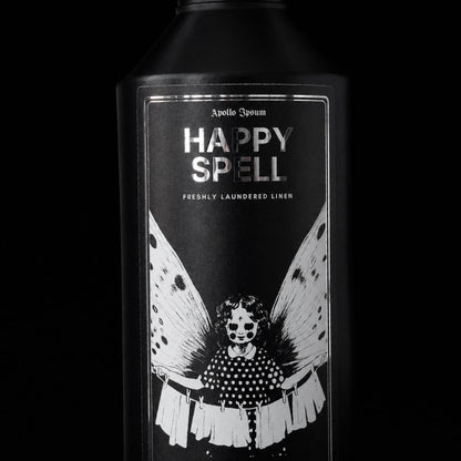 Close-up of the Happy Spell Fabric Perfume label on a fresh linen home fragrance spray