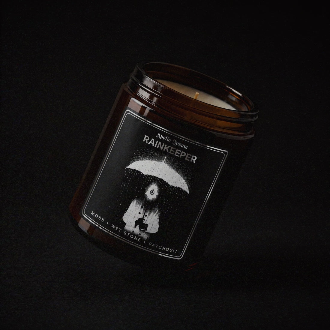 Rainkeeper soy wax candle in an amber jar with illustrated label, Apollo Ipsum Things That Shouldn&